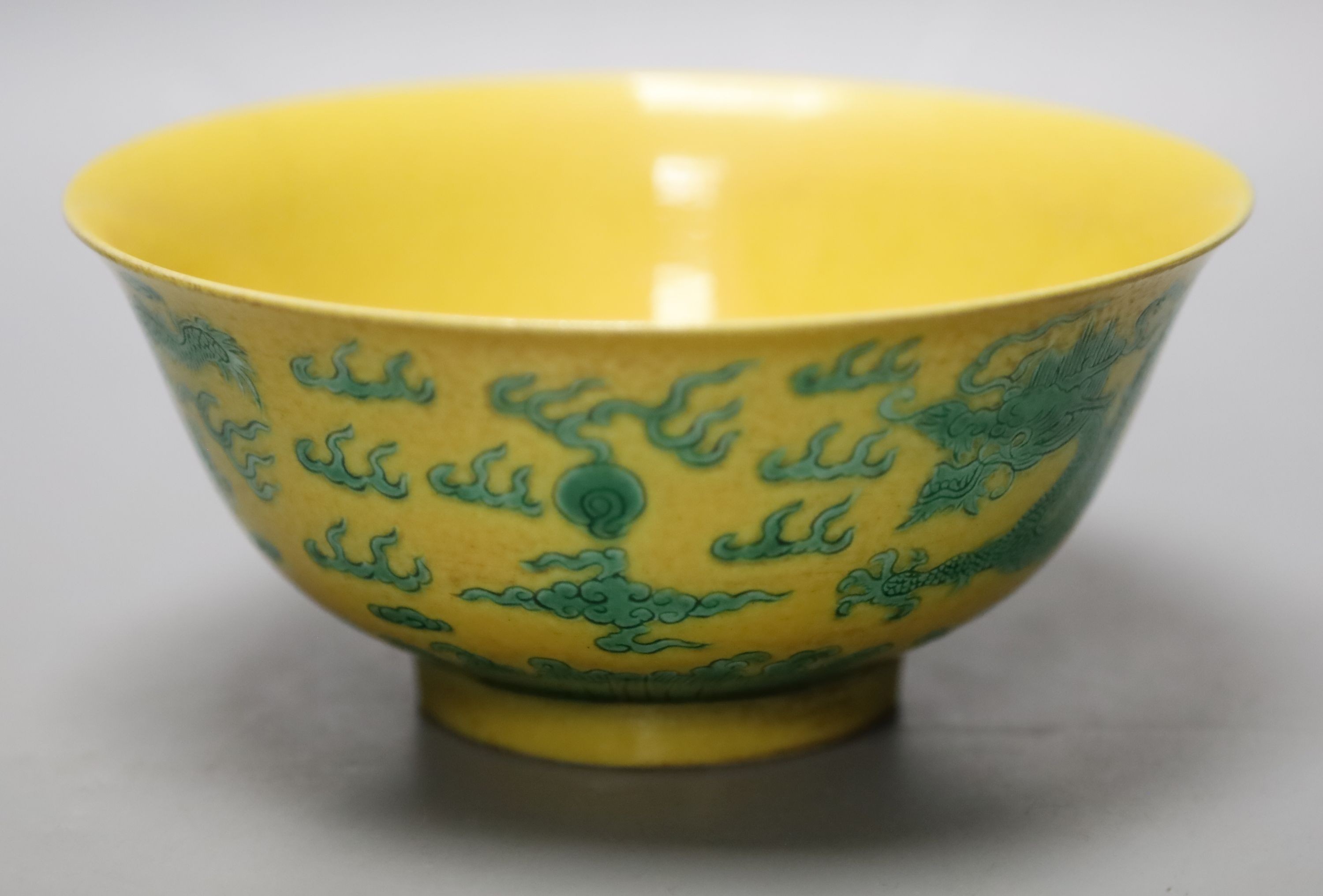 A Chinese yellow ground sgraffito’dragon’ bowl, Kangxi mark but later 15cm diameter